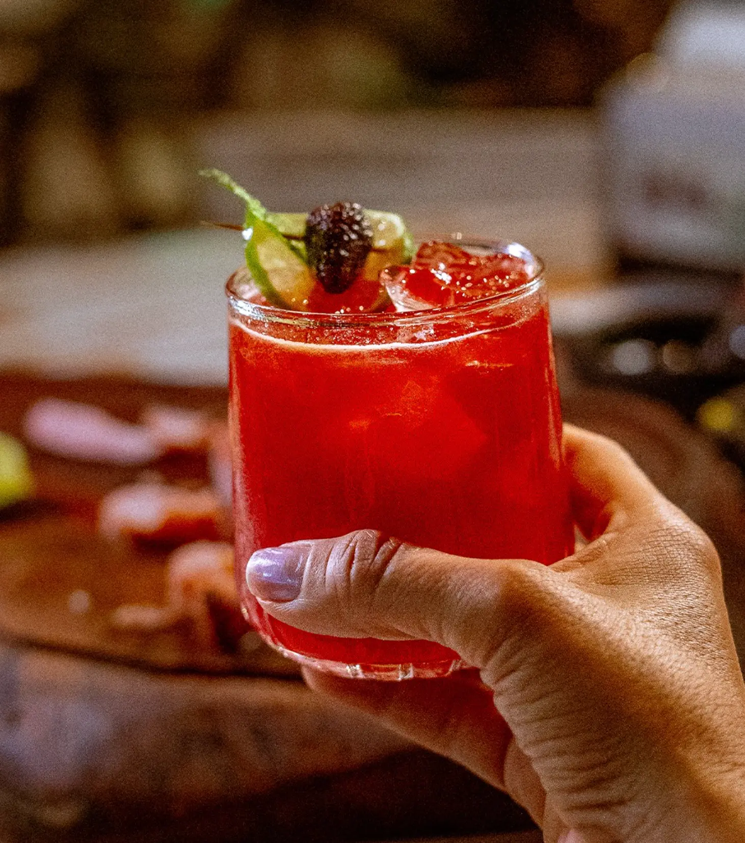 Drink vermelho com frutas na mão do cliente