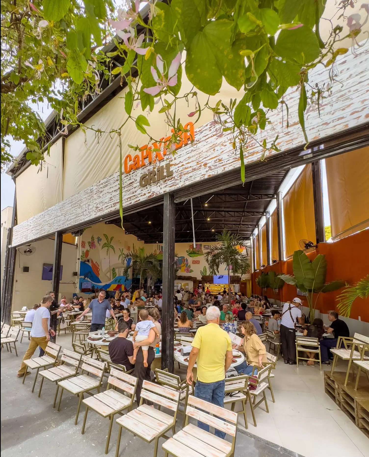 Fachada do Capixaba Grill com mural colorido e salão cheio