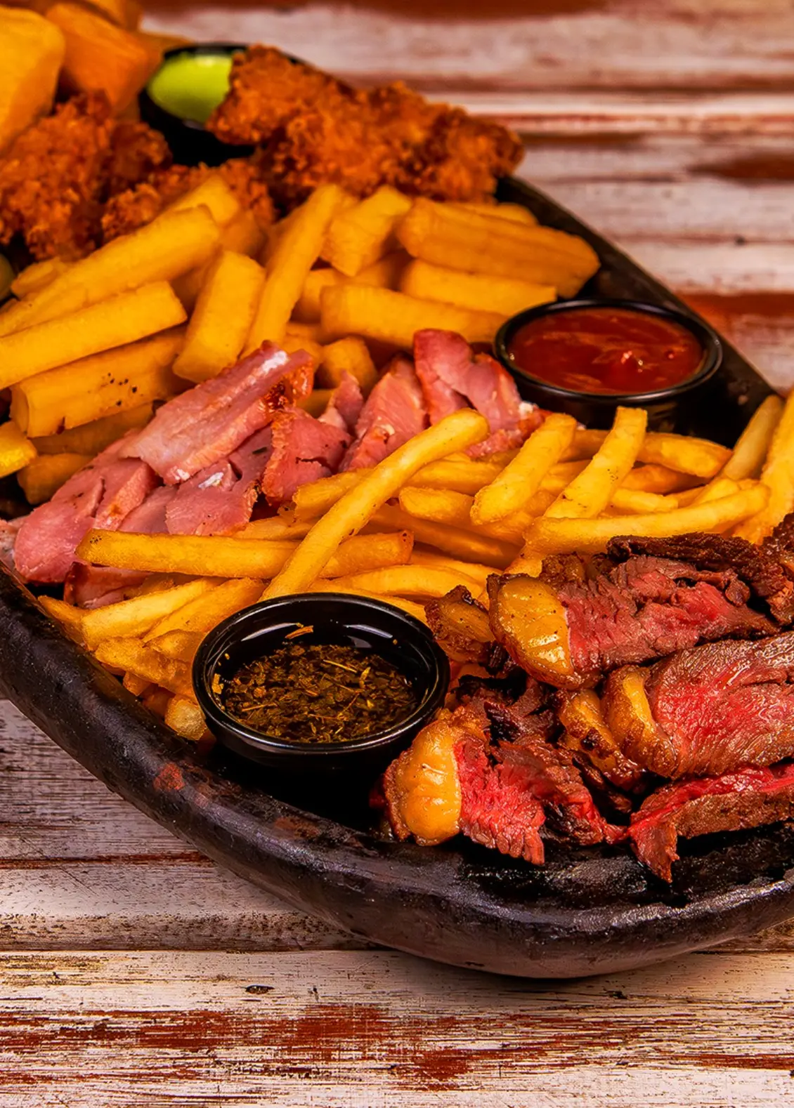Tábua servida com fritas e molhos da casa