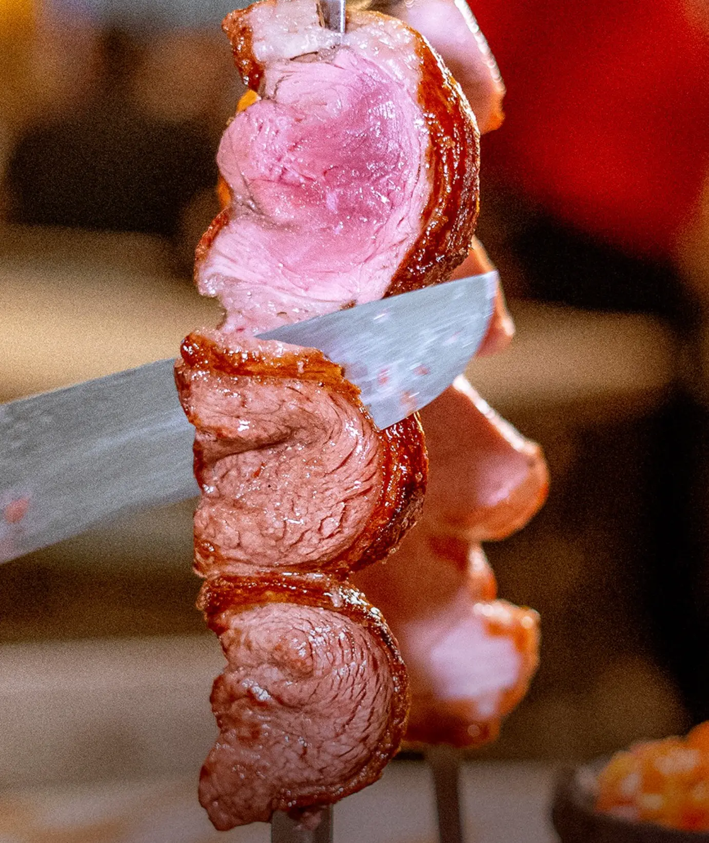 Espeto de picanha sendo fatiado na hora